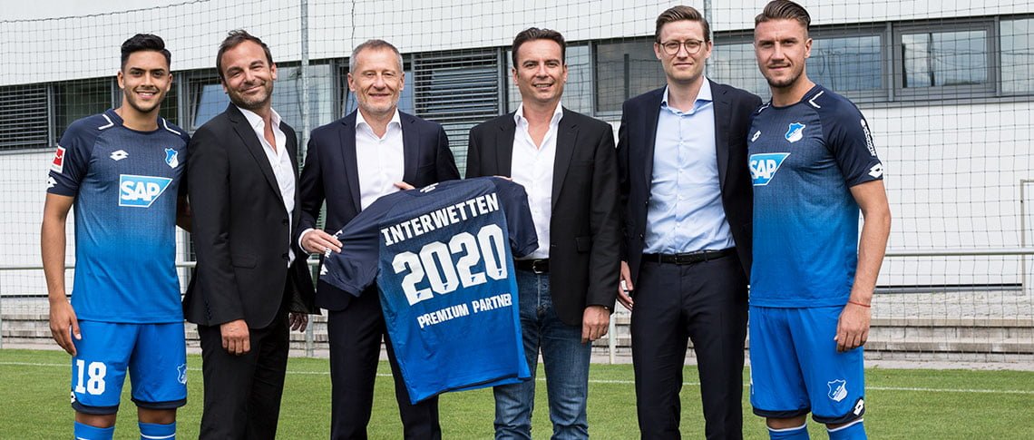 jugadores y dueños del VfL Wolfsburg posando con la camiseta de Interapuestas
